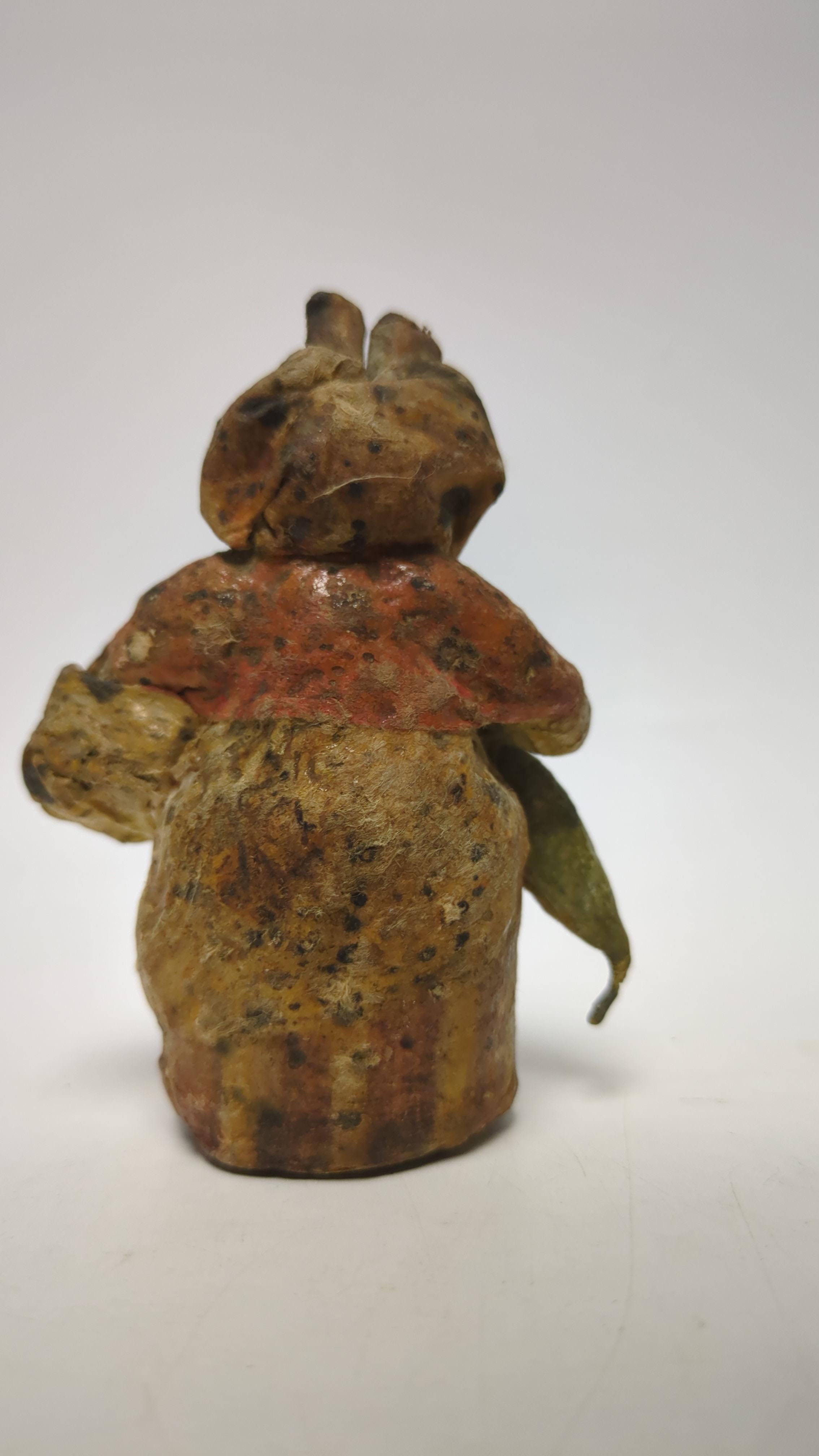 An F. Warne papier-mâché Beatrix Potter figure of Mrs. Rabbit with basket and umbrella, red and white F. Warne & Co. paper label to the base, dating it to pre-1917, 8.5cm high